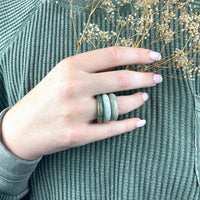 Thumbnail for A woman wearing a green sweater displays a jade polished ring from Bliss Crystals