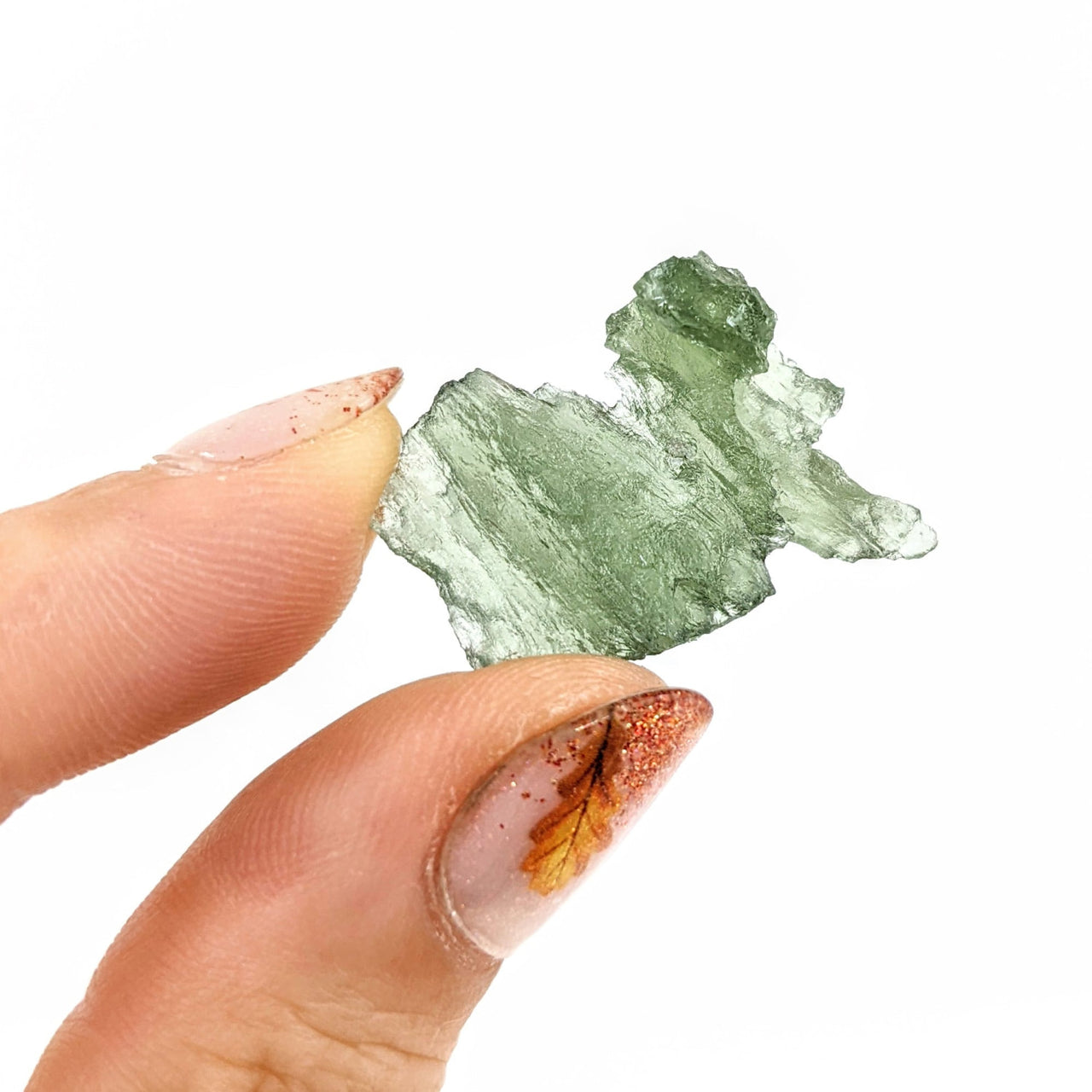 Hand holding a 1’ Moldavite Raw Besednice from Czech Republic, SKU #SK0564