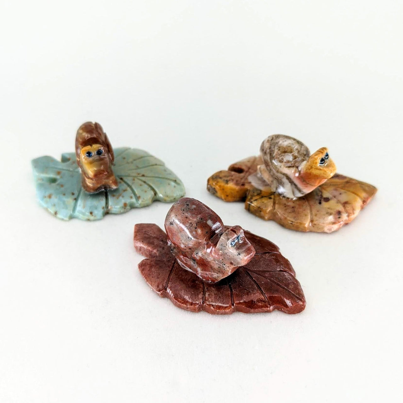 Three small pieces of glass with leaves on them for 1 Soapstone Baby Animal Carving from Peru