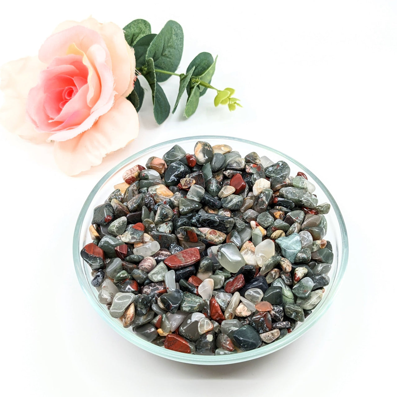 A bowl of African Bloodstone Gravel Mini Chips with a rose, 28g Parcel, #LV3088