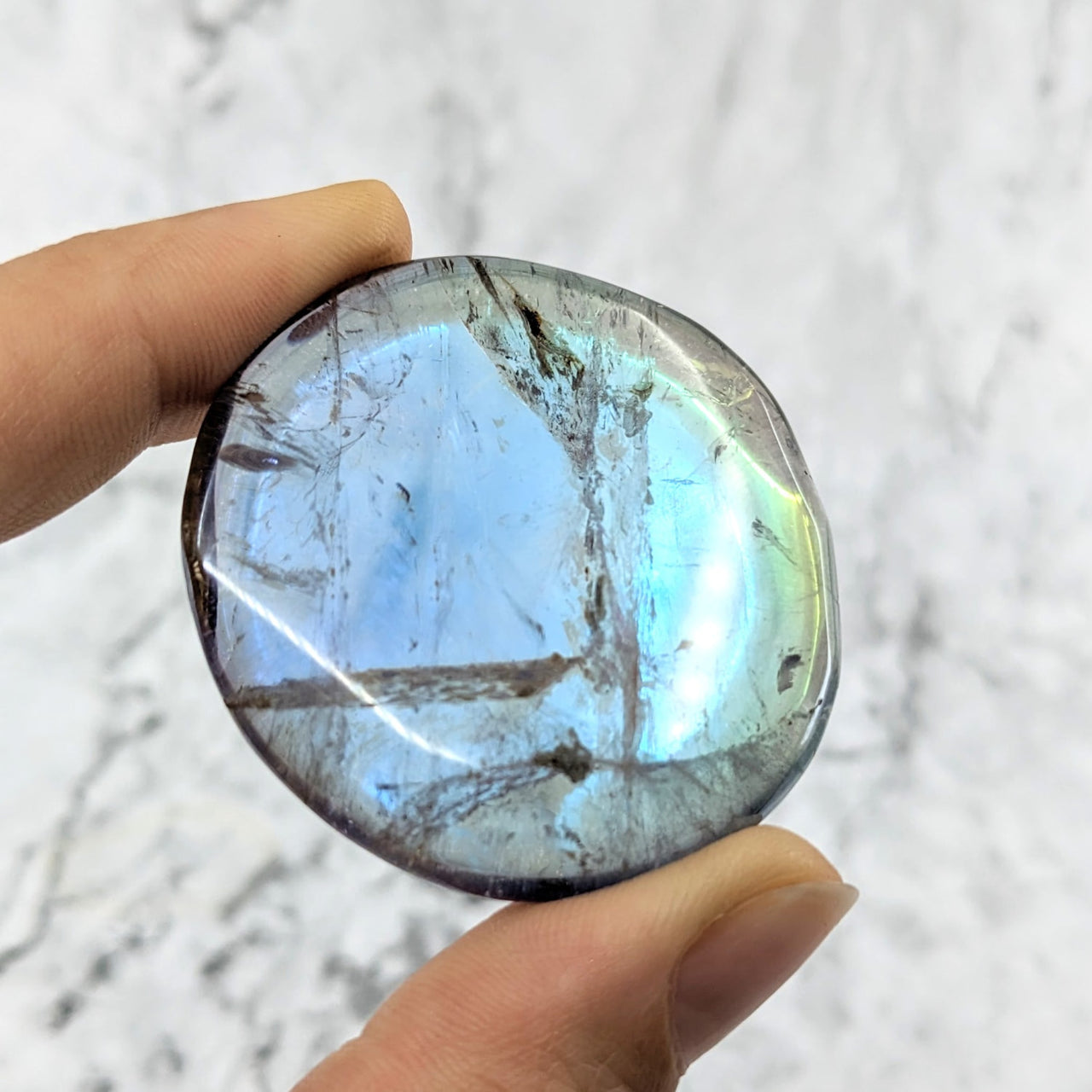 A blue and white quartz stone from the Amethyst Rainbow Aura Quartz Palm Stones collection