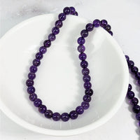 Thumbnail for Amethyst 4 mm round beads on a white plate on a white table, 12 pack #LV3615