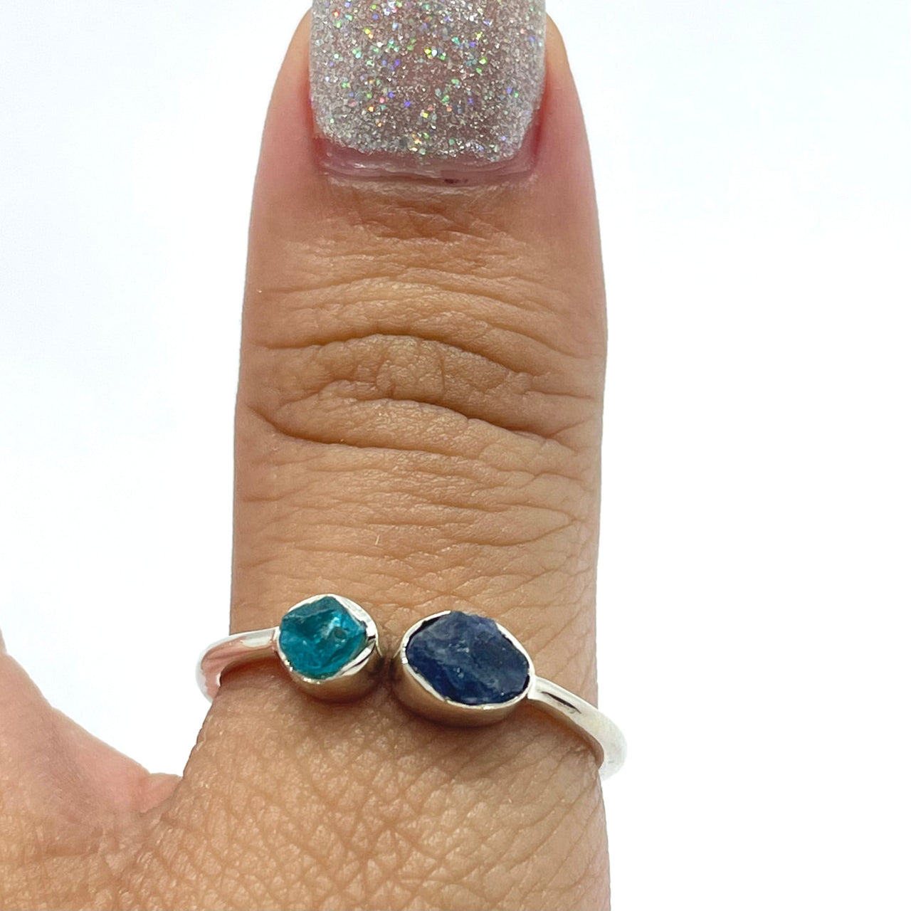 A woman’s hand wearing an Apatite & Blue Sapphire Dainty Adjustable SS Ring #J007