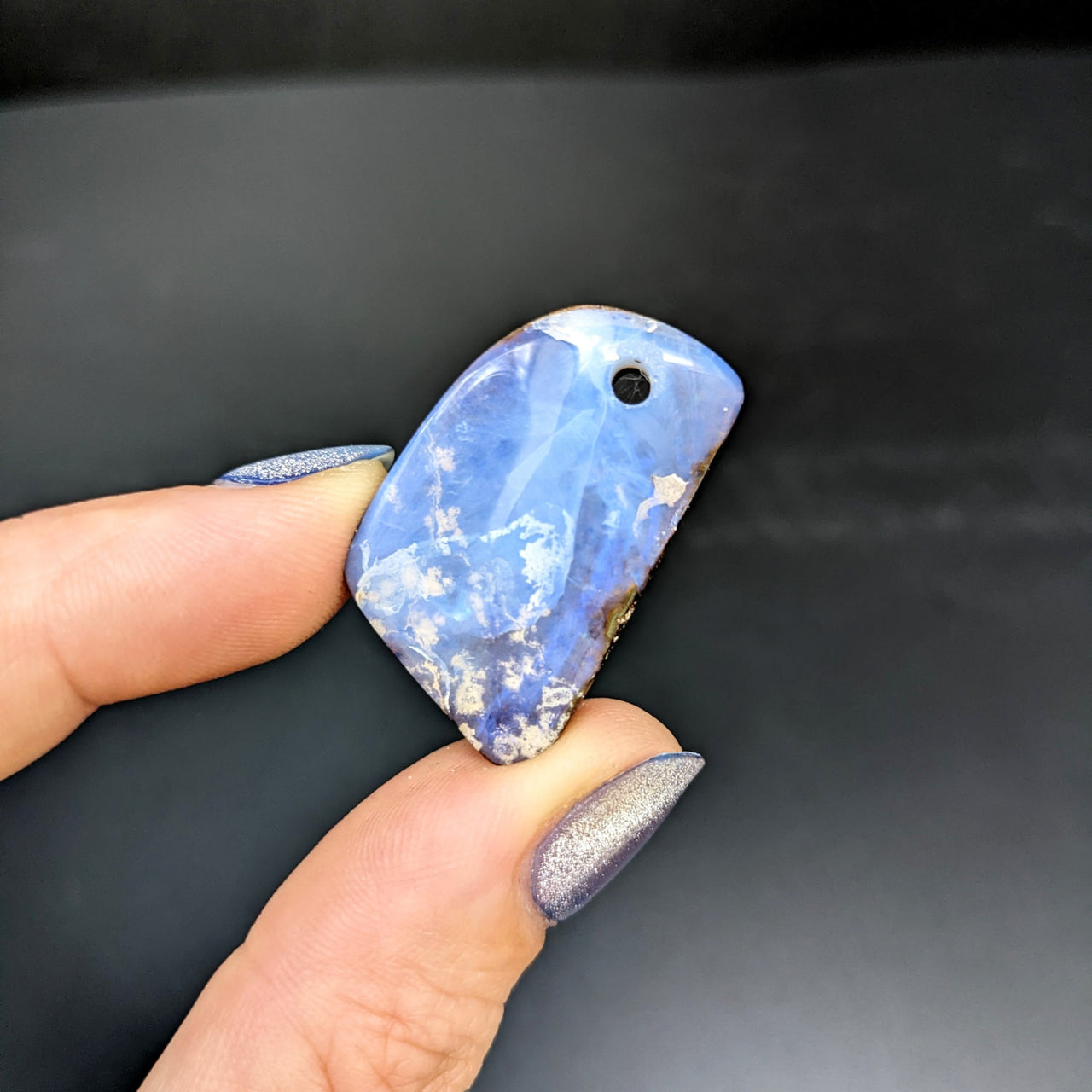 Person holding a blue and white Australian Opal Drilled Pendant (8g) #SK8833