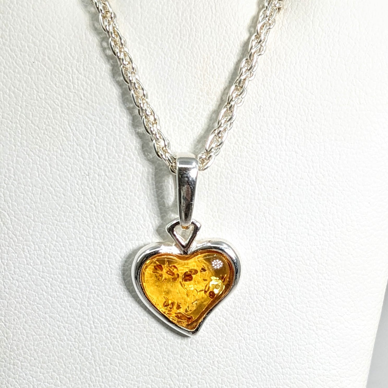 Close up of Baltic Amber heart-shaped pendant on a silver chain