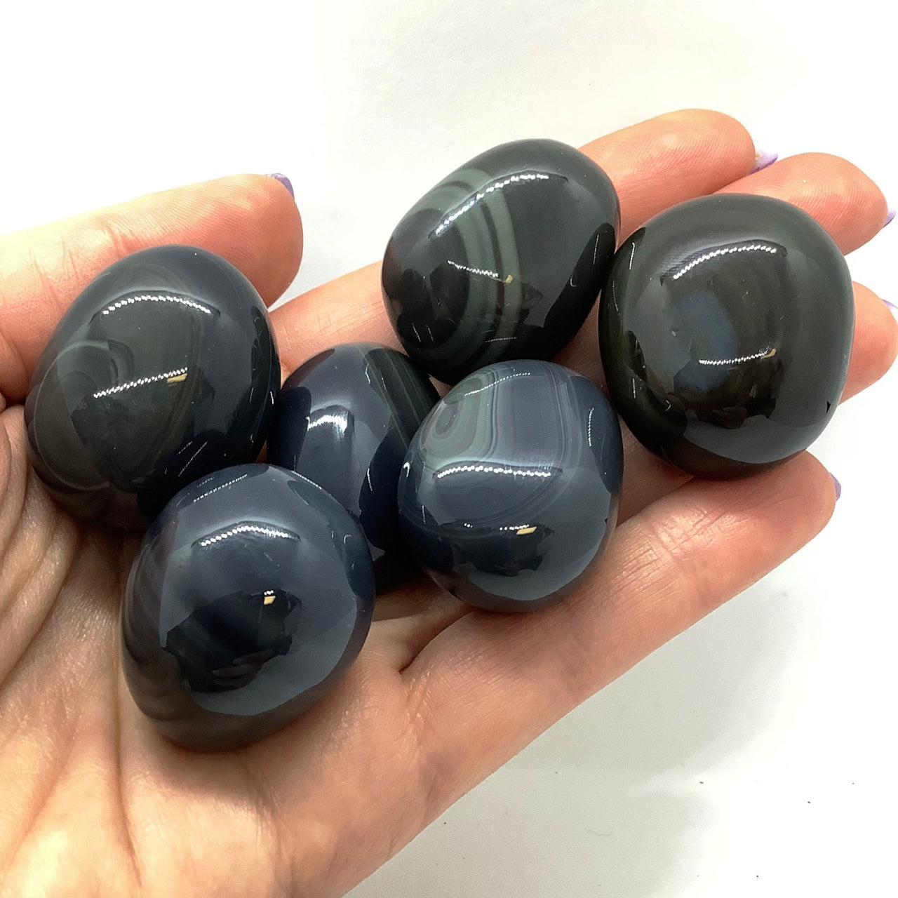 Person holding five BANDED Obsidian Tumbled Stones #PO33D in their hand