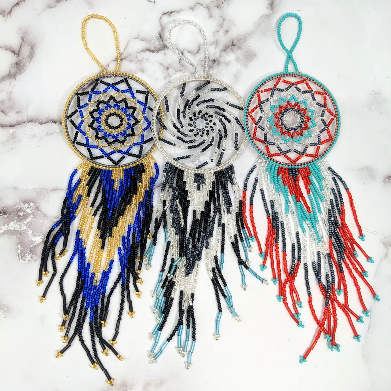 Beaded Guatemalan 9’ Dreamcatcher #LV2658 on marble surface with three intricate designs