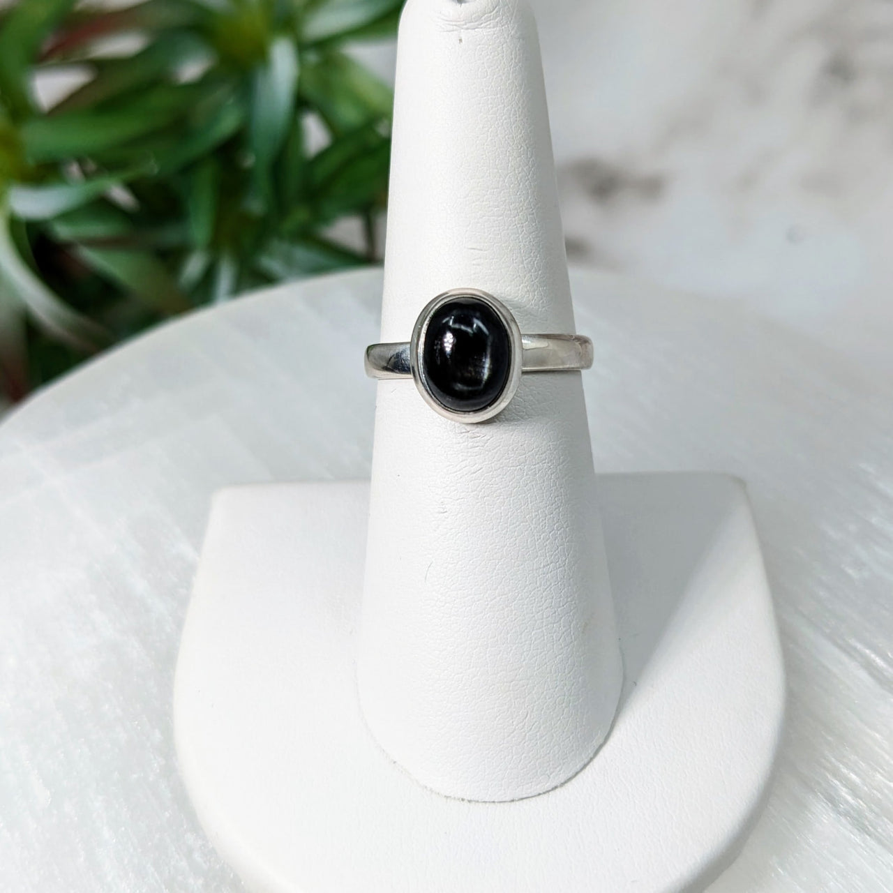 Black Star Sapphire S.S. Oval Ring #LV5012 displayed on a white ring stand