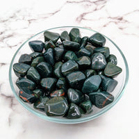 Thumbnail for Arafed glass bowl of Bloodstone Green tumbled stones on a marble table