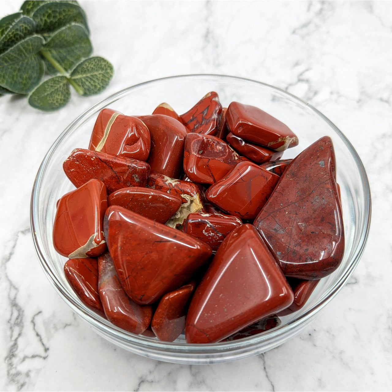 A bowl of red candies resembling Brecciated Red Jasper Tumbled #T043 on a marble counter