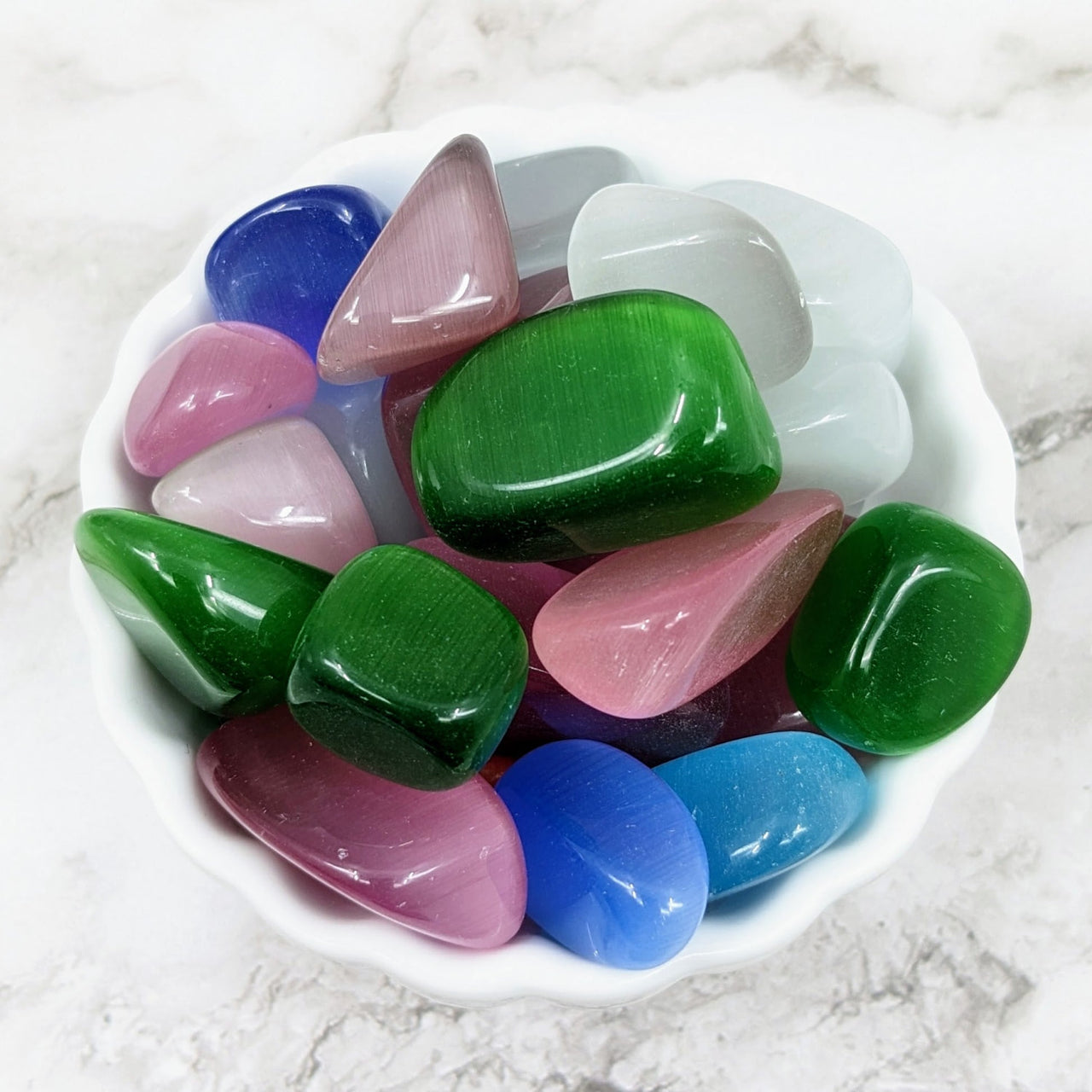 A bowl filled with colorful sea glass from the Cat’s Eye Tumbled Stones Bulk Lot #LV4097