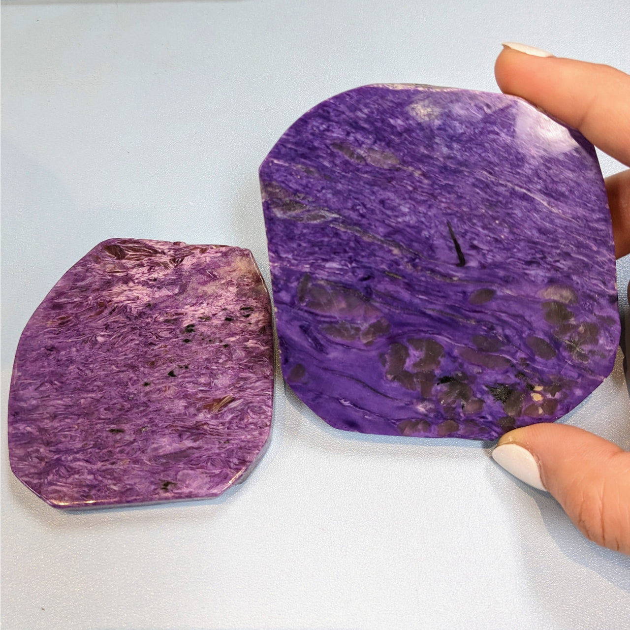 Close-up of a person holding flat-shaped purple Charoite Slab Grade AA #M176 stone