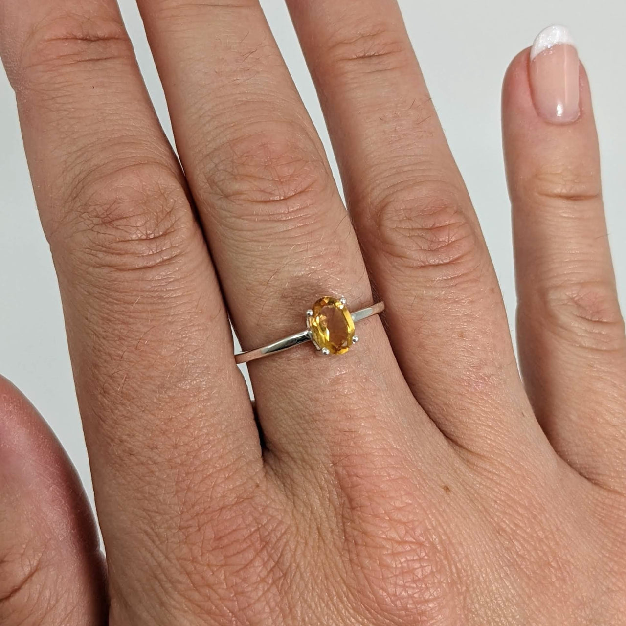 A woman’s hand with a Citrine Stackable Dainty Ring in .925 Sterling Silver