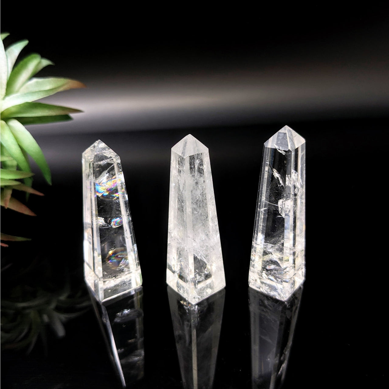 Clear quartz crystals 1.7-2.2’ obelisk tower #LV4720 on black surface