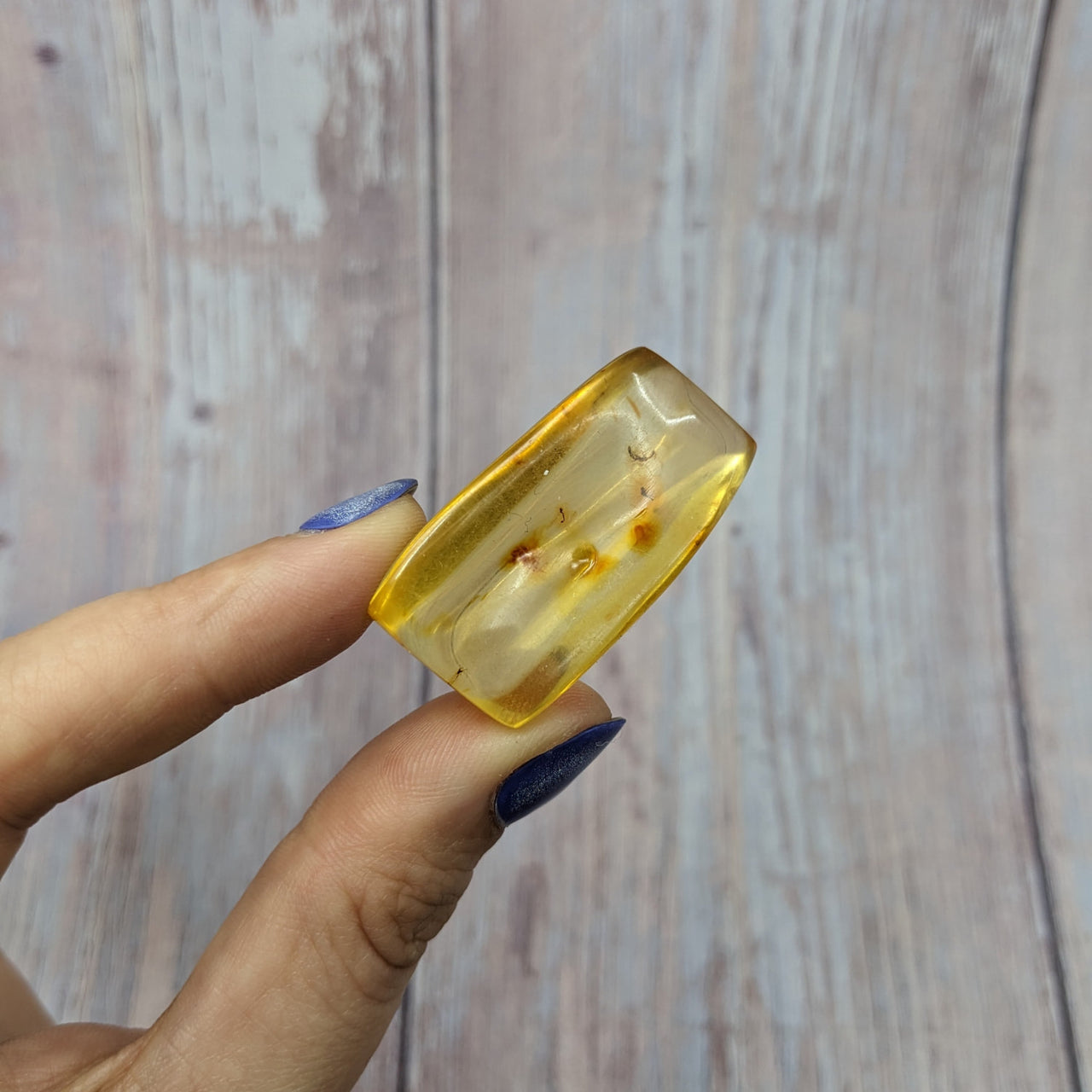 A woman holding a yellow glass ring made from Colombian Amber tumbled stones #SK9927