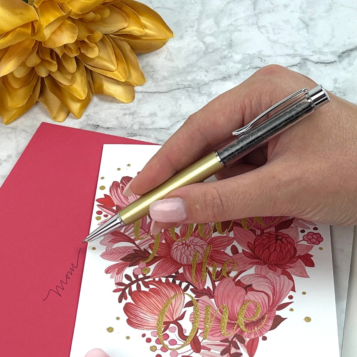 Drawing flowers on a card with a Crystal Manifesting Writing Pen in gold tone