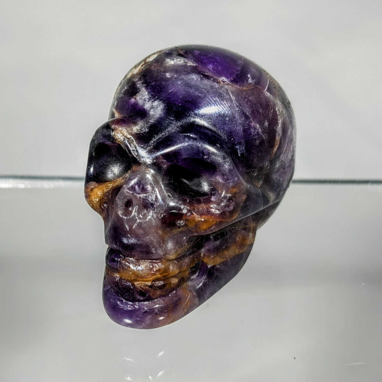 Tigers eye Crystal Skull Carving: detailed skull in purple, black, and white face