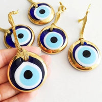 Thumbnail for Hand holding blue and white evil eyes, product: Evil Eye Wall Hangings #Q224