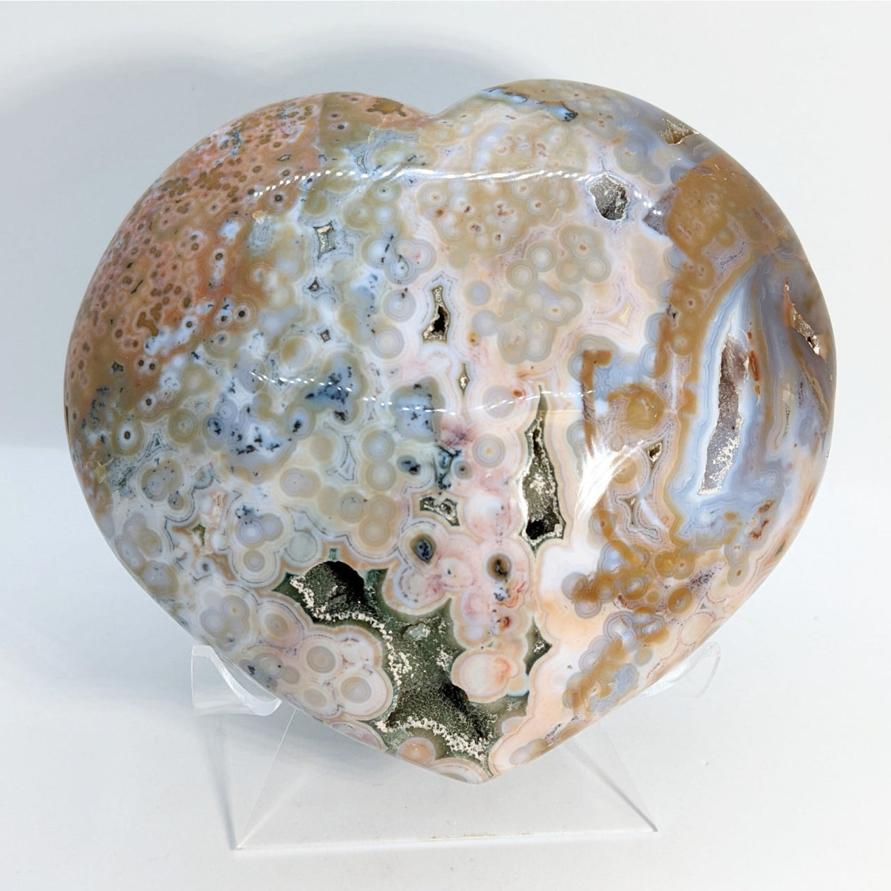 A large, multi-colored glass sphere from Extra Quality Ocean Jasper Marovato Heart + Stand