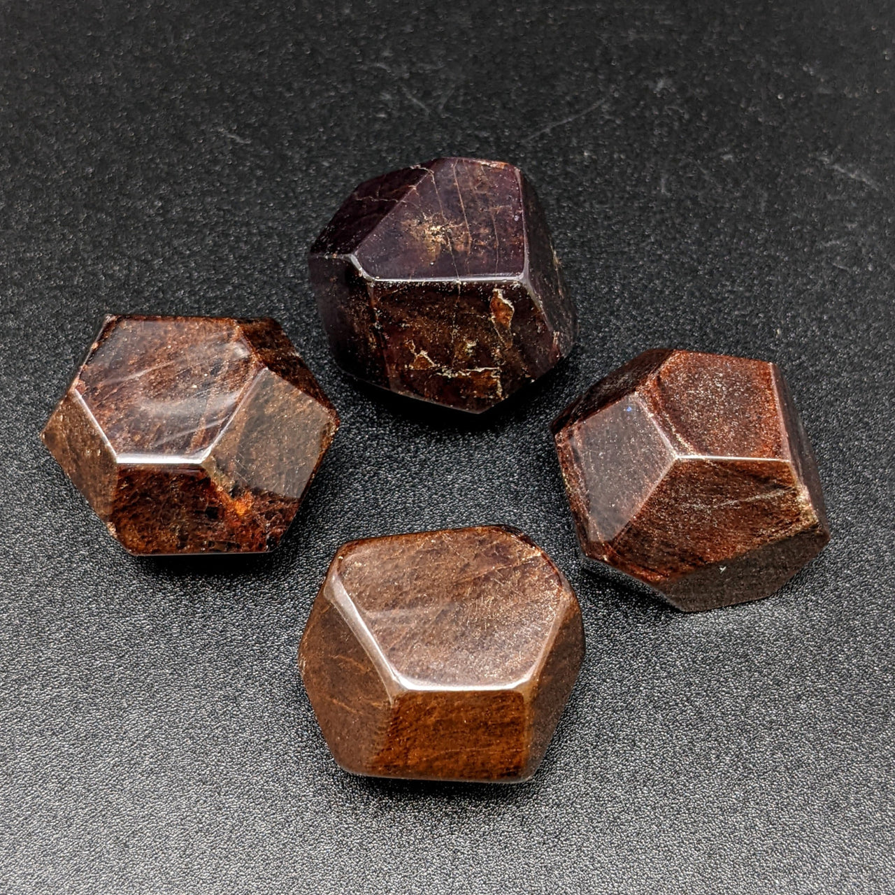 Three brown quartz stones on display, showcasing the faceted red garnet polygon #SK8089