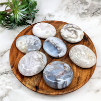 Thumbnail for Close-up of Flower Agate palm stone with rocks and plant on a wooden plate. #LV5145