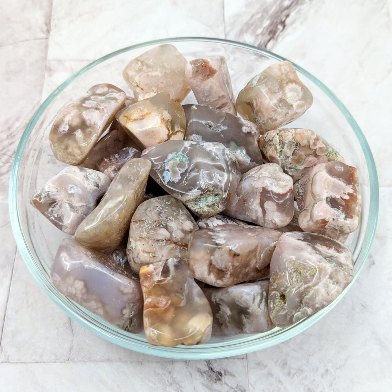 A bowl filled with ice and ice cubes showcasing Flower Agate Tumbled Stones (1-2’) #LV2272