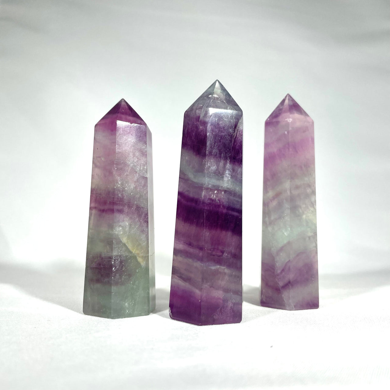 Fluorite Towers 2.5 - 3’ #G176: three amethite crystals on a white background