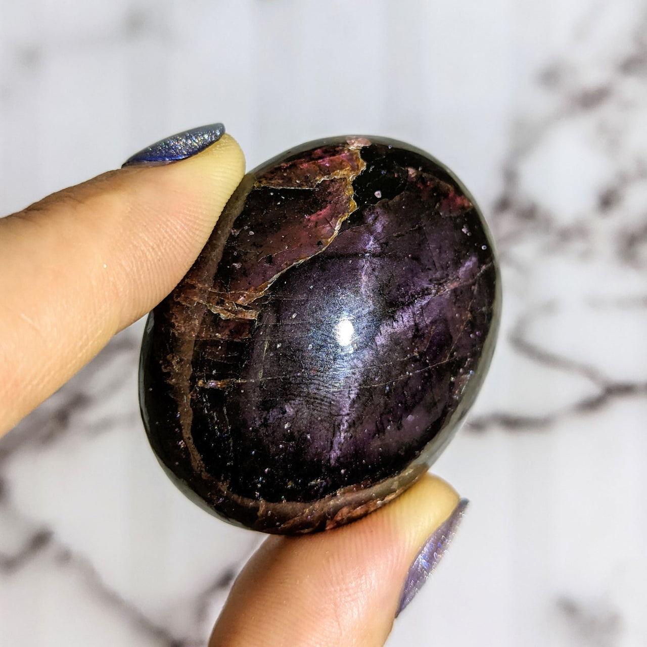 Person holding large purple Garnet aka Almandine palm stone #LV1428