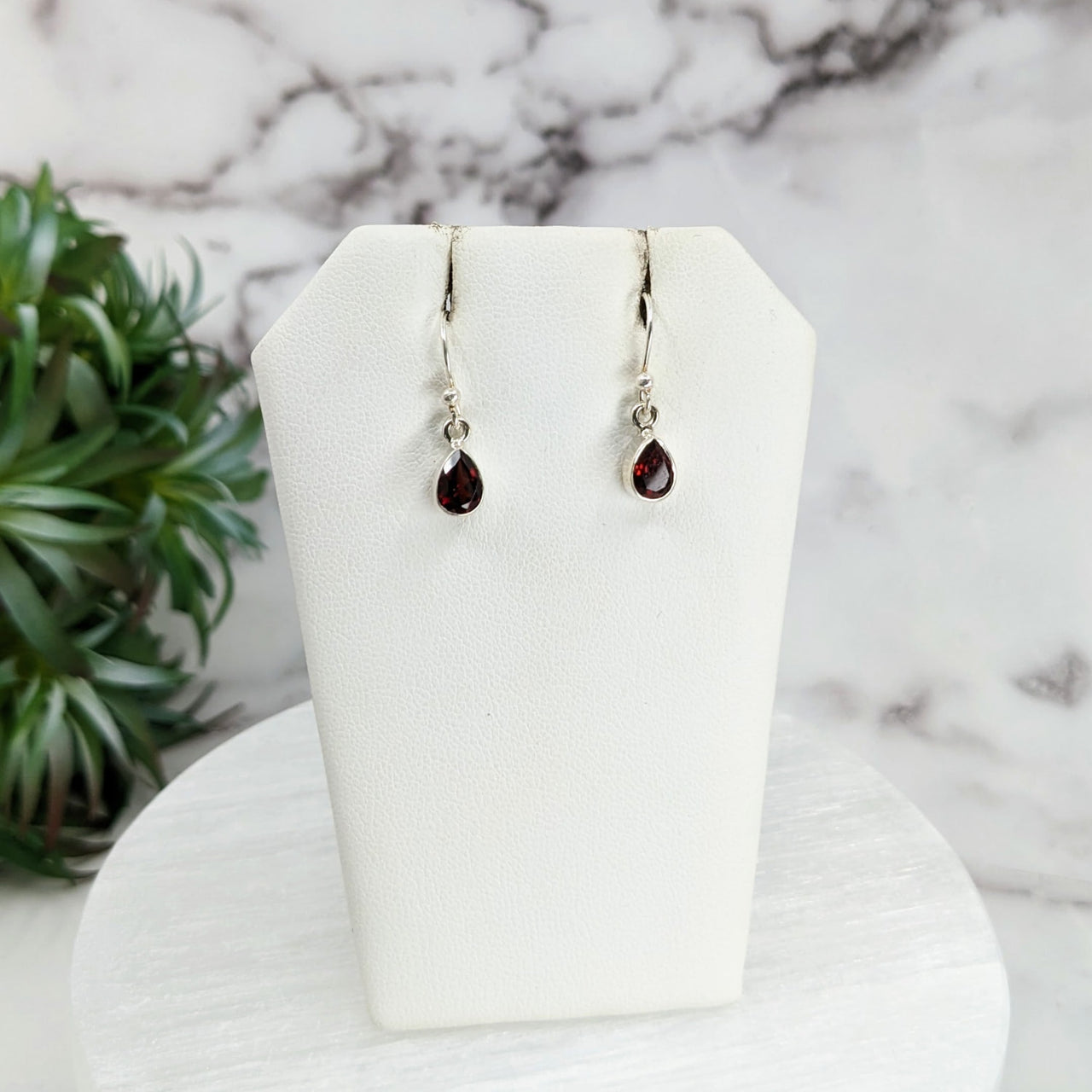 Garnet Faceted Sterling Silver Dangle Earrings on white display stand #LV3248