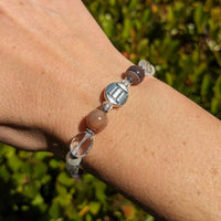 Thumbnail for A woman’s hand with a Gemini Zodiac Handmade Bracelet featuring hematite spacer beads