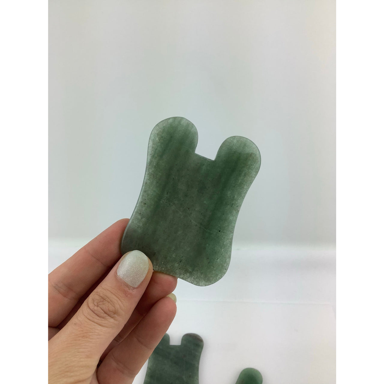 Hand holding green sea glass from Green Aventurine or Rose Quartz Gua Sha Massage Stones #K163D