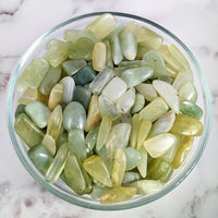 Thumbnail for A bowl filled with green and yellow tumbled stones, perfect for collectors