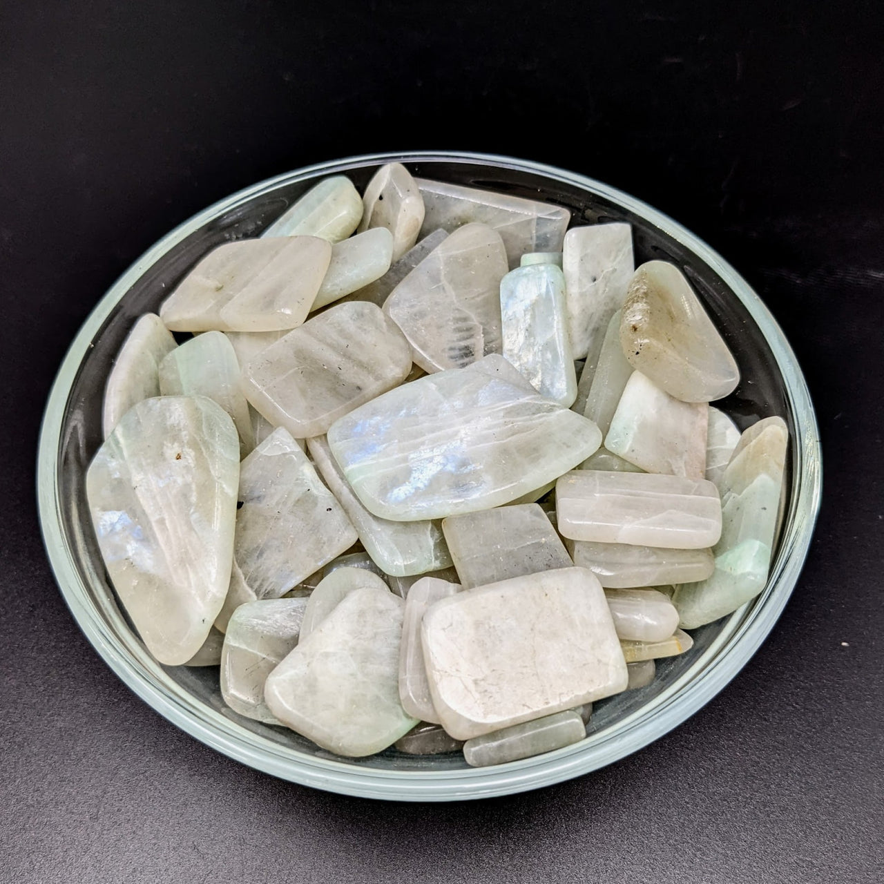 A bowl of green quartz crystals displayed in Green Moonstone A Slice, Assorted Size