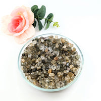 Thumbnail for A bowl of green and white crystals next to a rose - Green Tourmaline Gravel Mini Chips