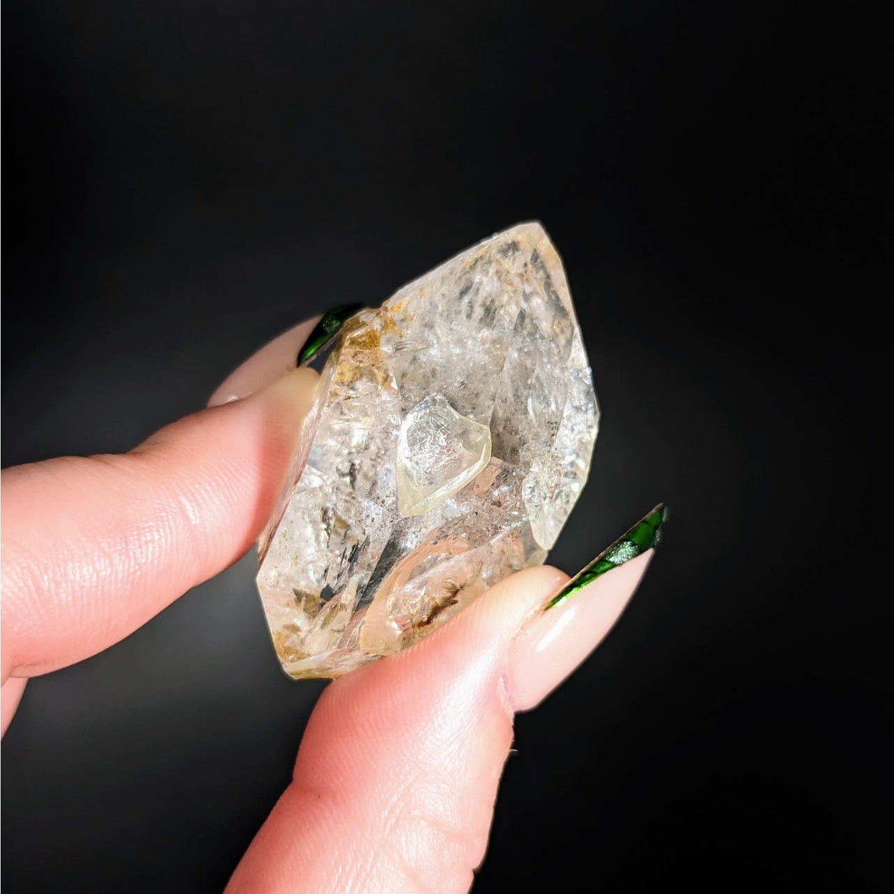 Hand holding a Herkimer Diamond 1.7’ Natural Point #LV4335 showing its clarity and brilliance