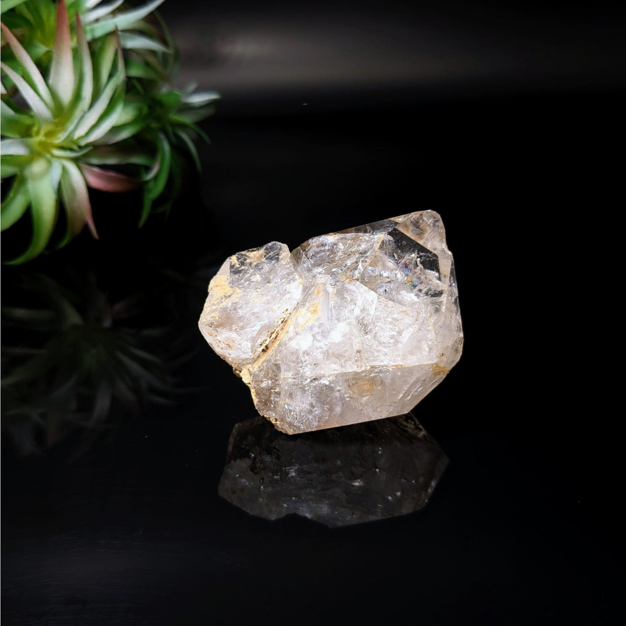 A rough Herkimer Diamond 2.1’ point on a black surface, product #LV4076