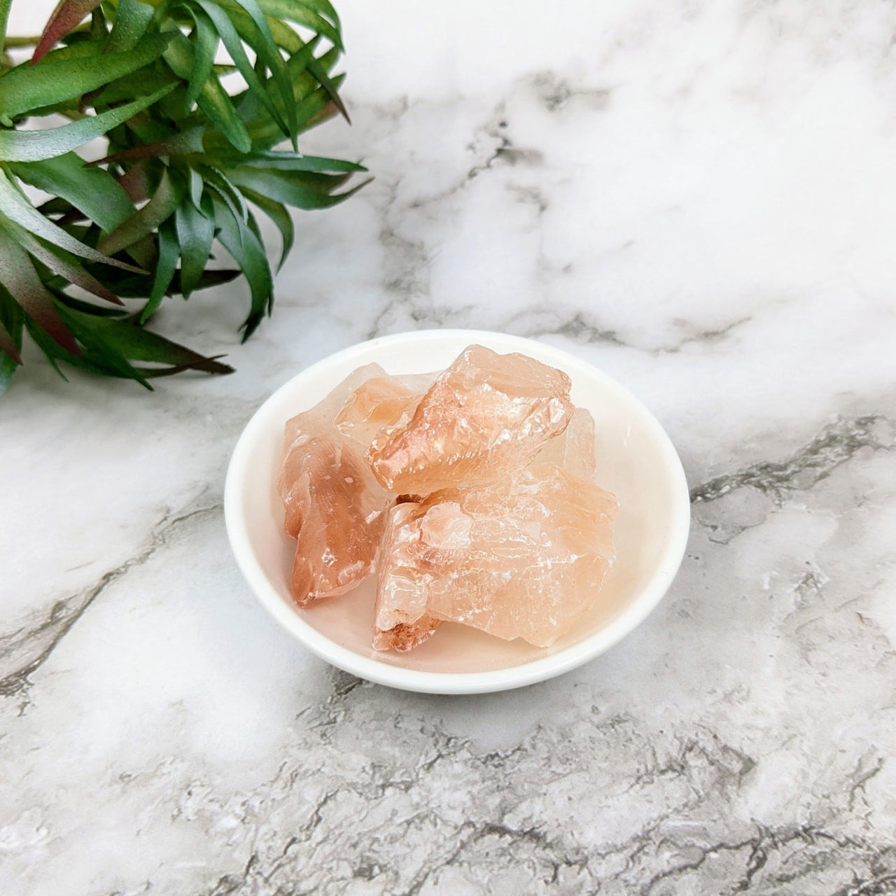 Bowl of raw chicken pieces on marble showcasing ’Icy Red Calcite Small 1.6-1.9’ Bulk Lot #LV4094’