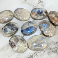 Thumbnail for Close-up of Iridescent Sunfire 2’ Moonstone Palm Stones on Marble Surface – LV4064