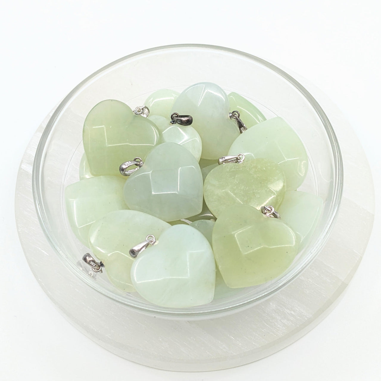 A bowl filled with green jade hearts for the Jade Green Faceted Heart Pendant #LV1856