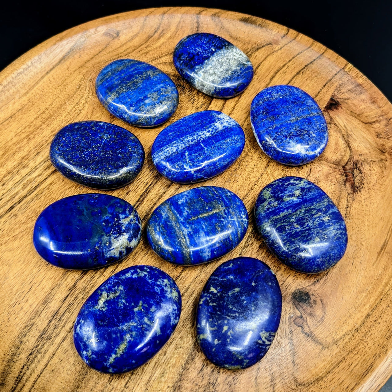 Close-up of a wooden plate with blue palm stones from Lapis Lazuli collection #LV2718