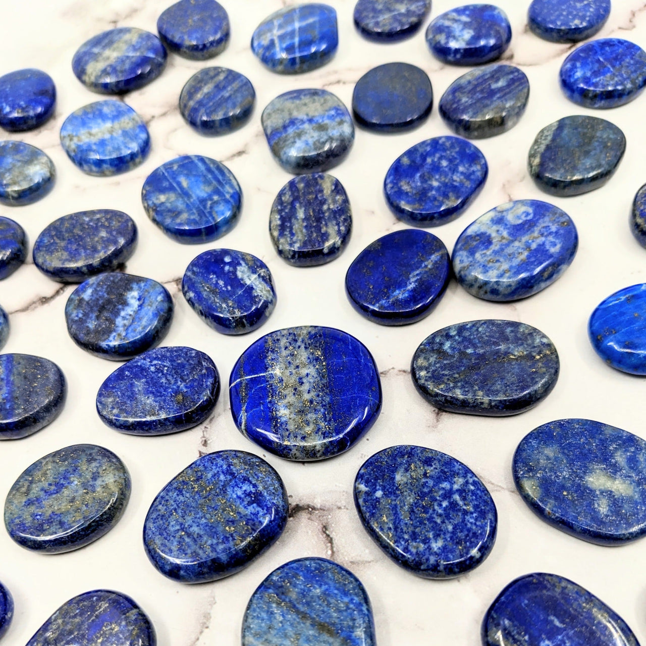 Close-up of blue Lapis Lazuli palm stones on a table, product code SK9948