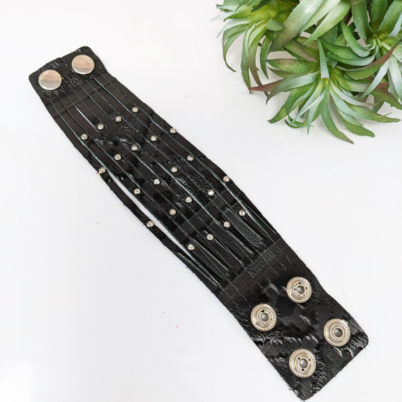 Black leather bracelet with metal buttons, rhinestones, and adjustable 9 strands