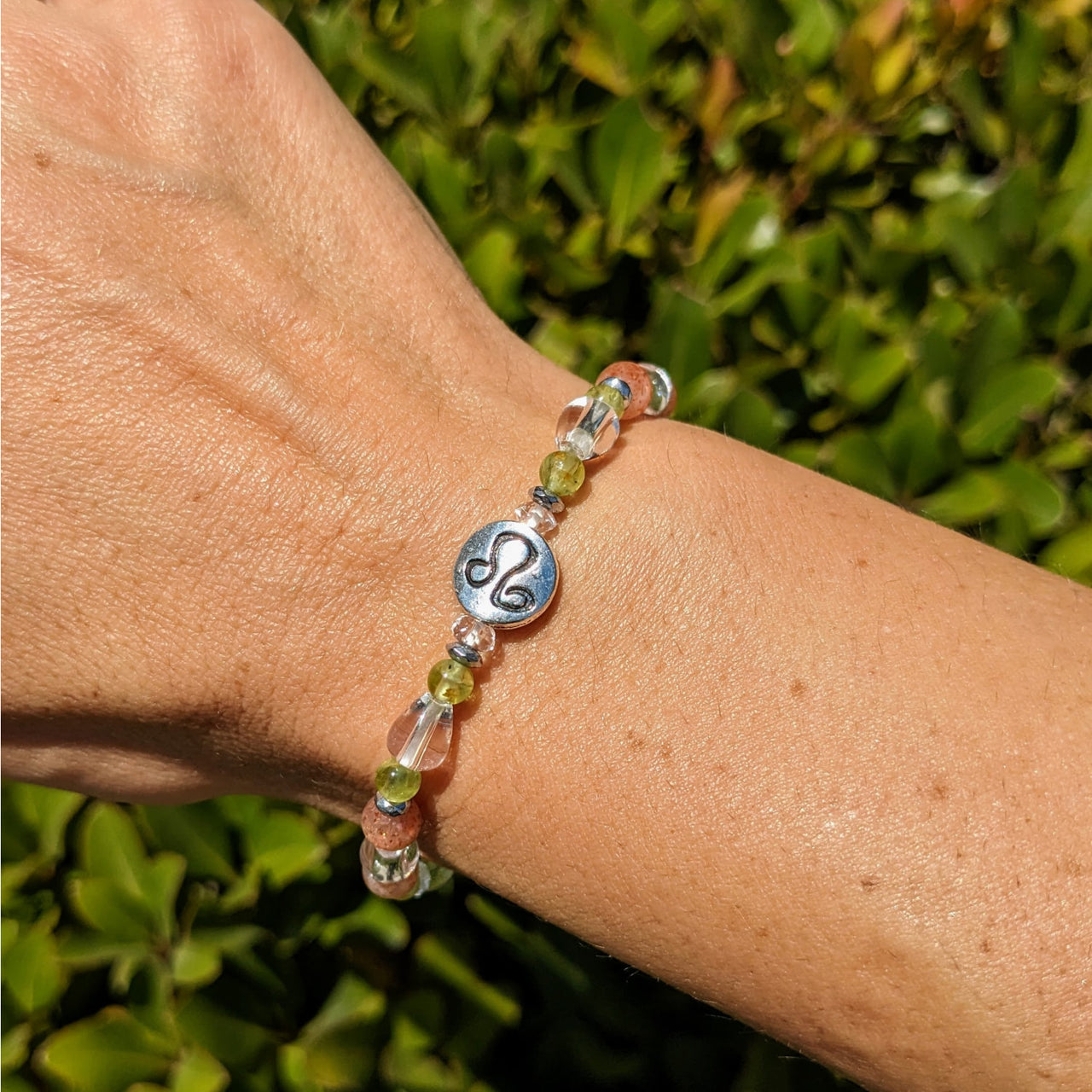 Woman’s hand wearing Leo Zodiac Handmade Beaded Bracelet with glass and silver beads