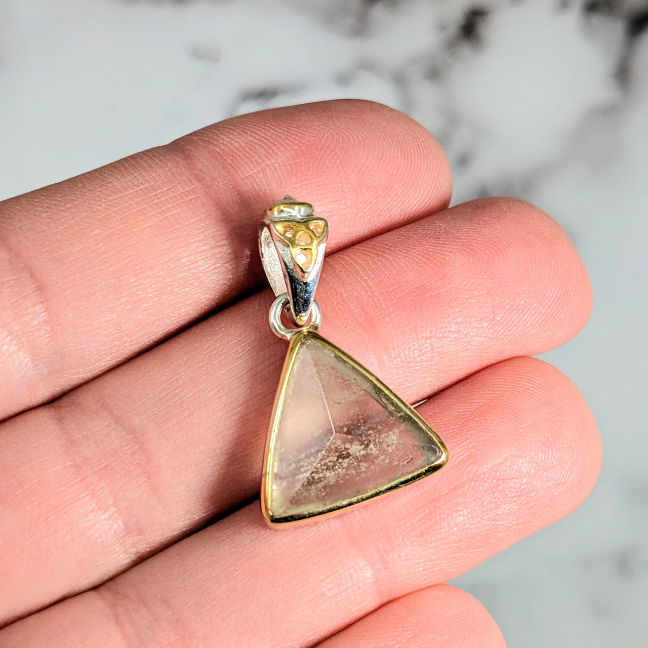 Person holding Libyan Desert Glass gold triangle pendant #LV2613 against a plain background