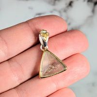 Thumbnail for Person holding Libyan Desert Glass gold triangle pendant #LV2613 against a plain background