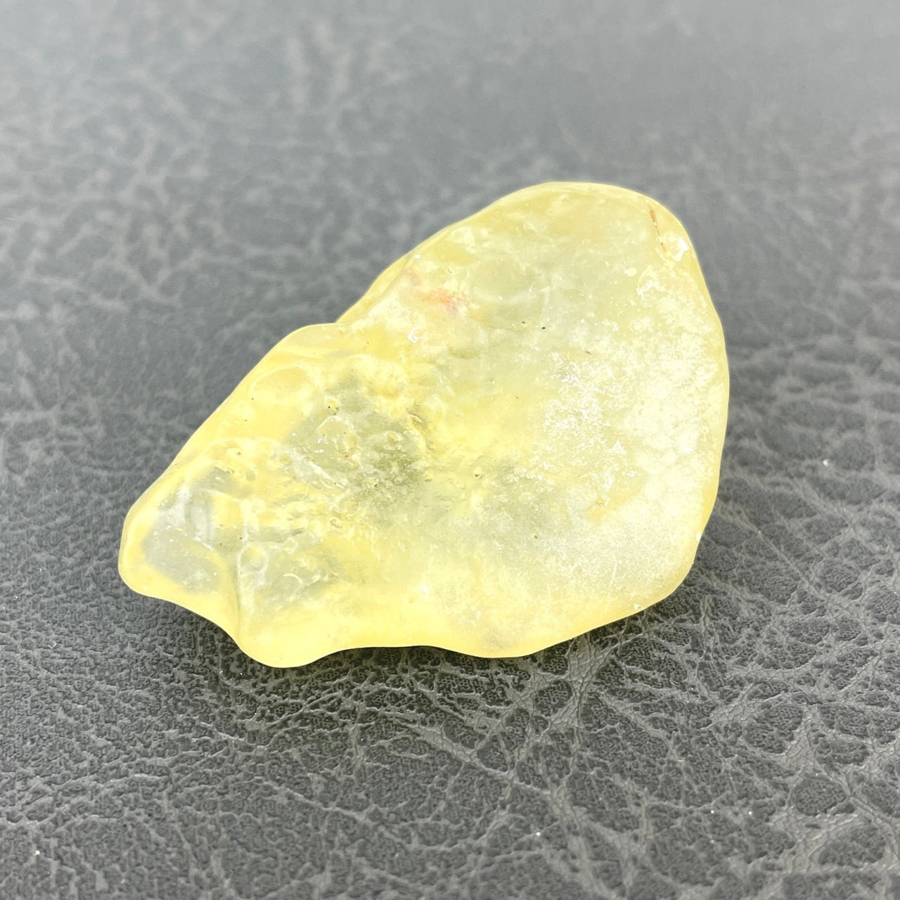 Libyan Desert Glass 2’ Specimen #LV1337: Yellow Quartz Stone on Black Surface