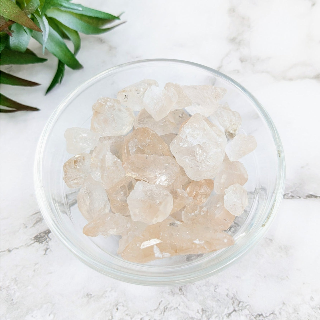 Bowl of ice crystals on marble counter with Light Gold Topaz Rough Stone #LV4316