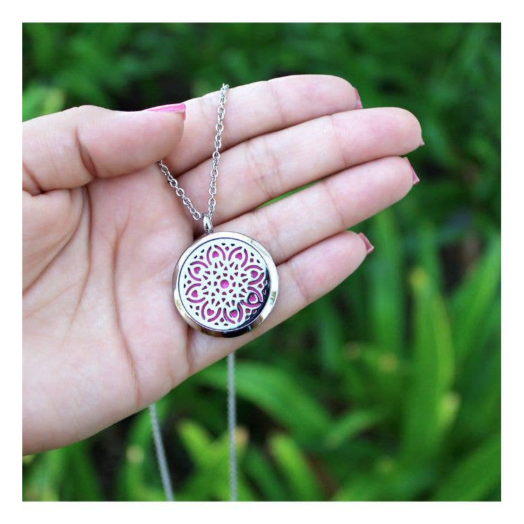 A hand holding Mandala Aromatherapy Necklace #P001389 with pink flower, perfect gift box item