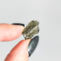 Thumbnail for A person holding a green glittering piece of Moldavite 0.81g Rough Piece #SK9453