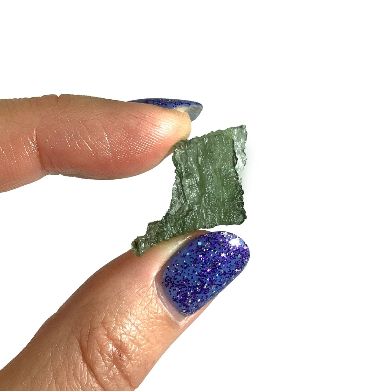 Person holding vibrant moldavite raw Besednice gemstone from the Czech Republic